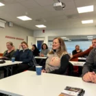 personer som sitter i ett konferensrum och ser på en föreläsare