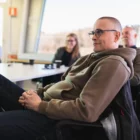 fyra personer som sitter i ett konferensrum och kollar på en föreläsning