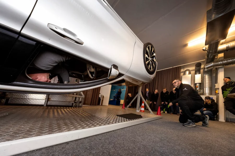 En person sitter i vältbilen och en grupp människor tittar på utifrån bilen.
