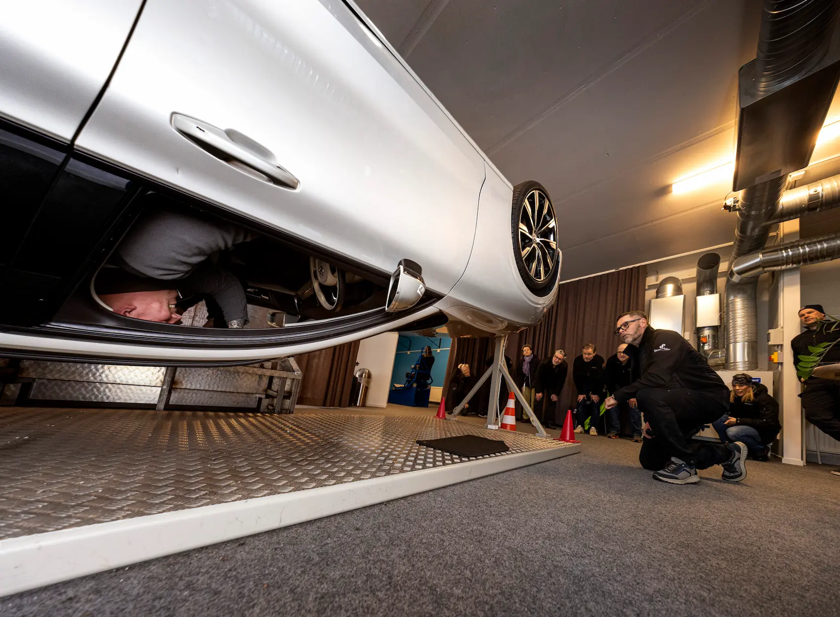 En person sitter i vältbilen och en grupp människor tittar på utifrån bilen.