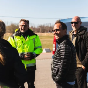 Anställda som står och diskuterar tillsammans med instruktör på halkbanan